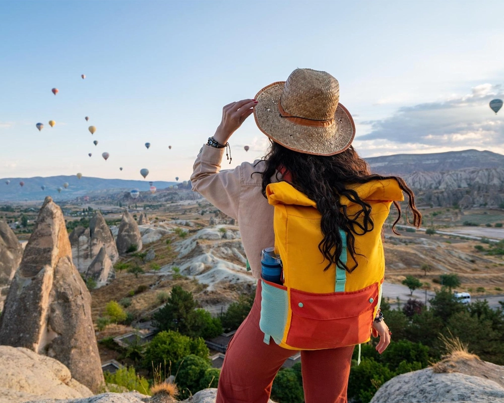 Traveler enjoying a local Cappadocia experience with hot air balloons over the valleys
