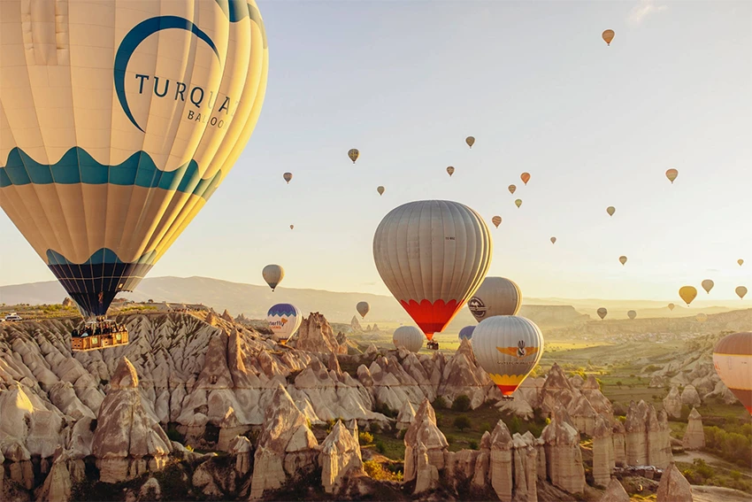 Hot air balloons flying over Göreme at sunrise