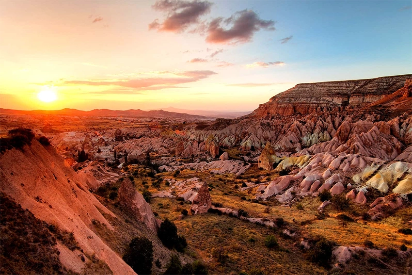 Sunset view from Red Valley terrace with glowing red tuff rocks and distant Mount Erciyes
