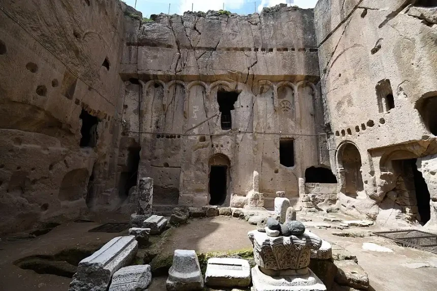 Open rock-cut courtyard surrounded by rooms at Gümüşler Monastery