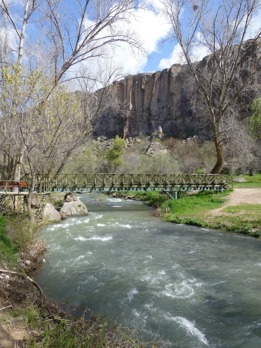 Melendiz River flowing beneath trees and volcanic canyon walls in Ihlara Valley