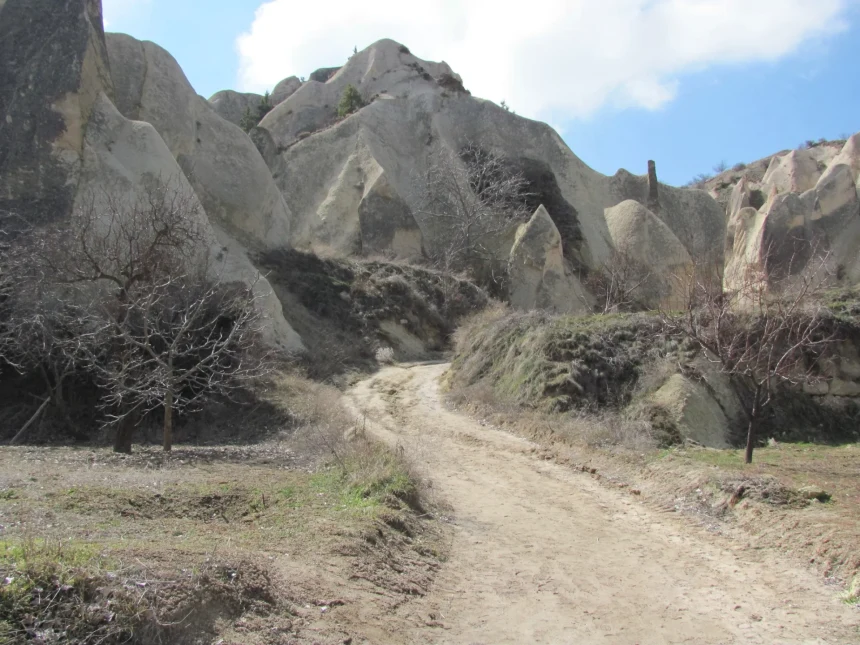 Marked hiking path through pink volcanic formations in Rose Valley